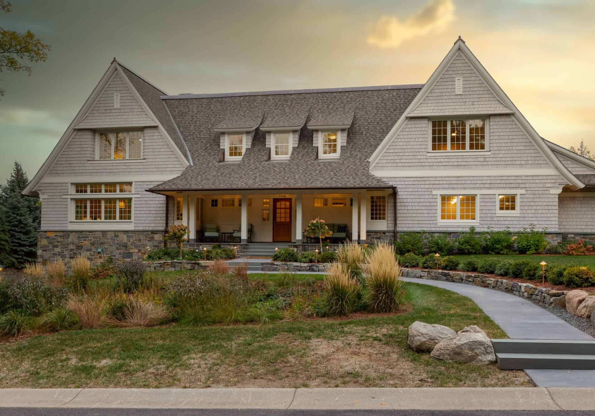 picture of a charming house with stone accents and a shingled roof.